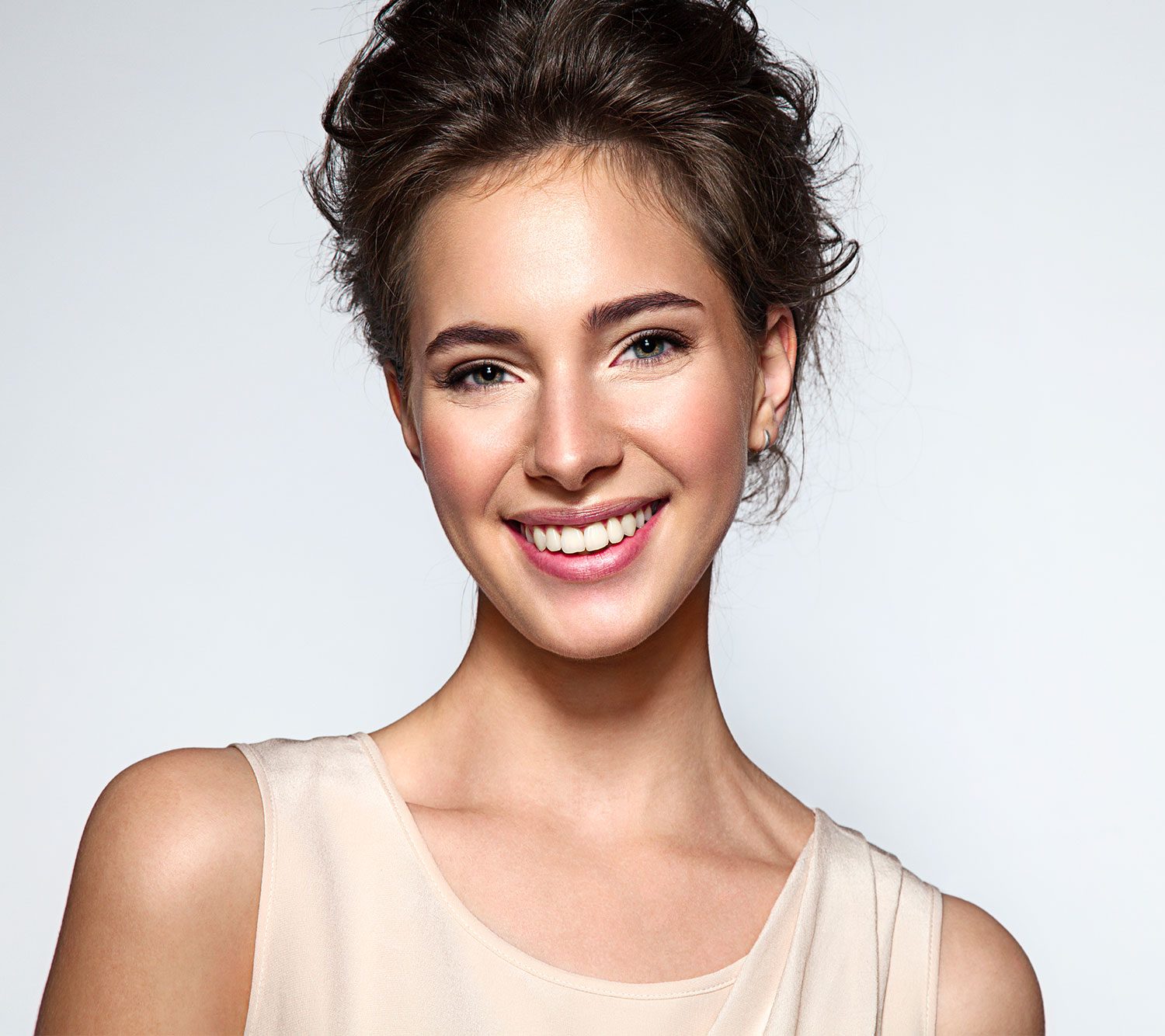 Portrait d'une femme souriante au maquillage naturel, sourcils dessinés